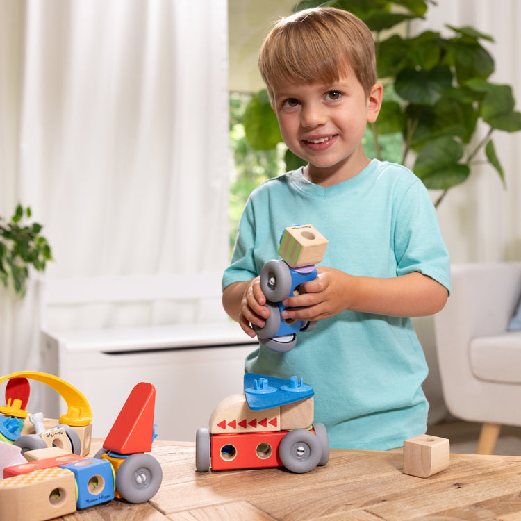 A kid playing with The Melissa & Doug Blockables™ Vehicles Snap And Play, Mix And Match Connectable Wooden Building Blocks Play Set Toy for Preschool Boys And Girls (54 Pcs)