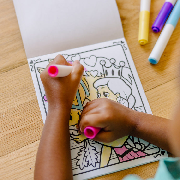 A kid playing with The Melissa & Doug On the Go Magicolor Coloring Pad - Princess (18 Pages)
