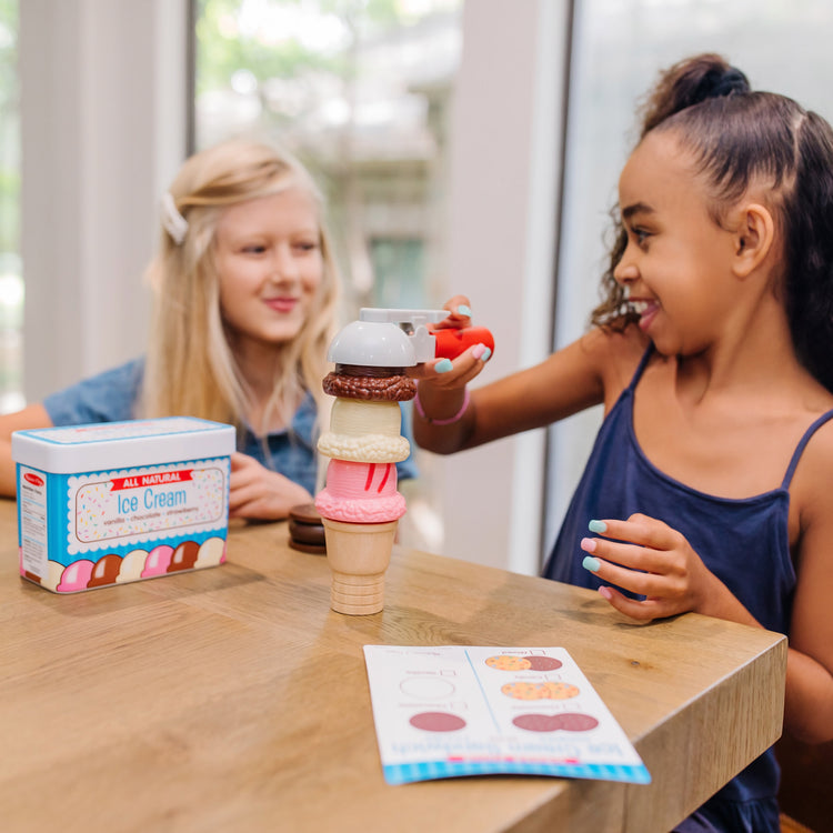A kid playing with The Melissa & Doug Scoops and Sandwiches 13-Piece Ice Cream Play Food Set