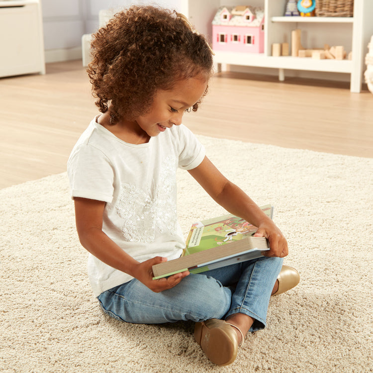 A kid playing with The Melissa & Doug Children's Book - Poke-a-Dot: 10 Little Monkeys (Board Book with Buttons to Pop)