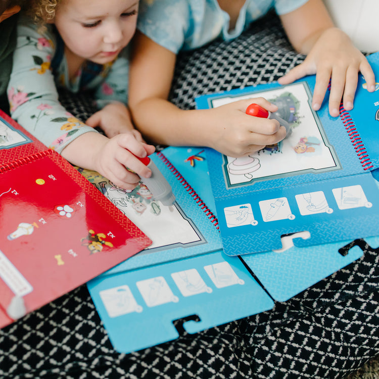 A kid playing with The Melissa & Doug PAW Patrol Water Wow! 3-Pack - Skye, Chase, Marshall Water Reveal Travel Activity Pads