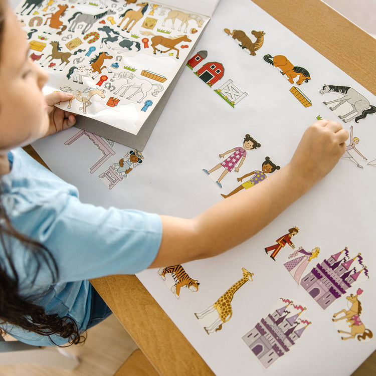 A kid playing with The Melissa & Doug Sticker Collection and Coloring Pads Set: Princesses, Fairies, Animals, and More