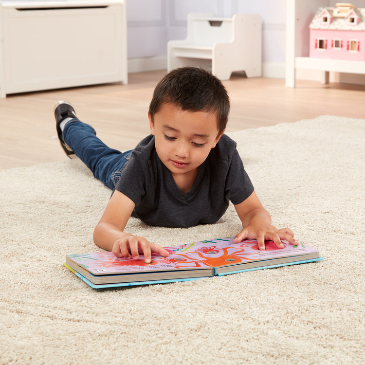 A kid playing with The Melissa & Doug Children's Book - Poke-a-Dot: Who’s in the Ocean (Board Book with Buttons to Pop)