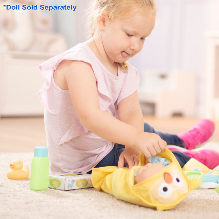 A kid playing with The Melissa & Doug Mine to Love Changing & Bathtime Play Set for Dolls – Diapers, Pretend Shampoo,Wipes, Towel,  More (19 pcs)