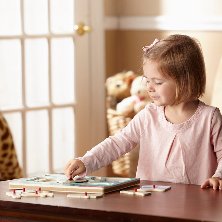 A kid playing with The Melissa & Doug Musical Instruments Sound Puzzle - Wooden Peg Puzzle (8 pcs)