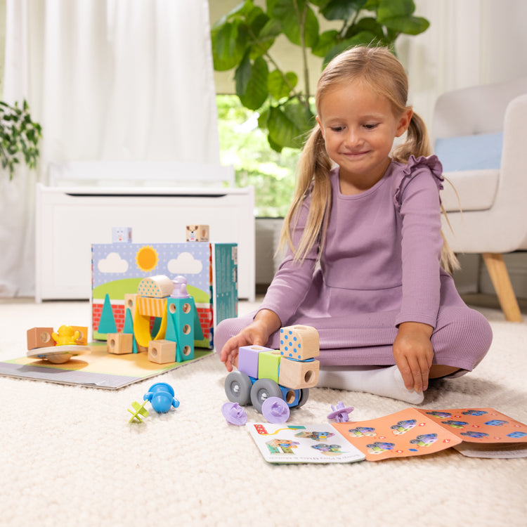 A kid playing with The Melissa & Doug Blockables™ Town Snap And Play, Mix And Match Connectable Wooden Building Blocks Play Set Toy for Preschool Boys And Girls (73 Pcs)