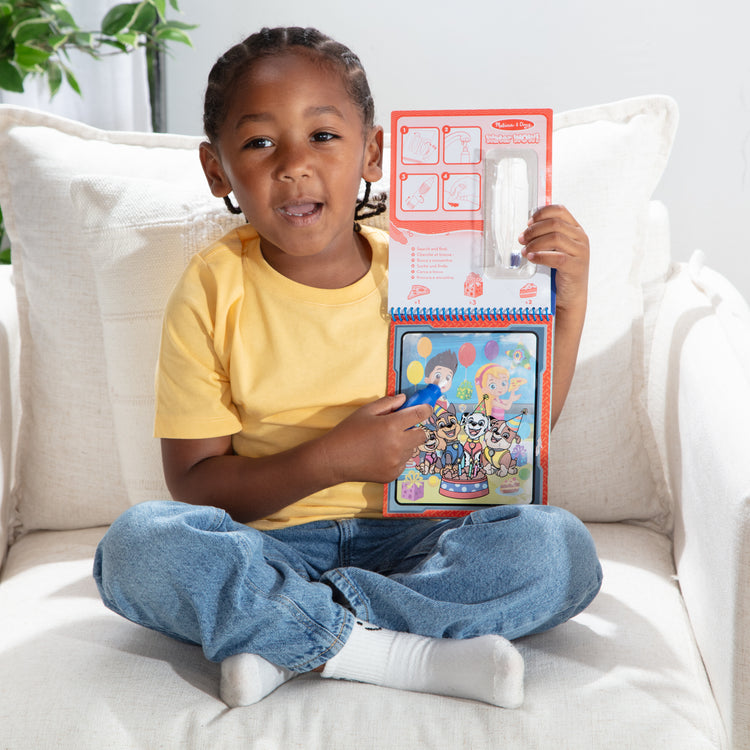 A kid playing with The Melissa & Doug Water WOW! PAW Patrol Chase Reusable Coloring Book with Refillable Water Pen - For Ages 3+