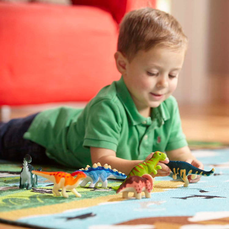 A kid playing with The Melissa & Doug Dinosaur Party Play Set - 9 Collectible Miniature Dinosaurs in a Case
