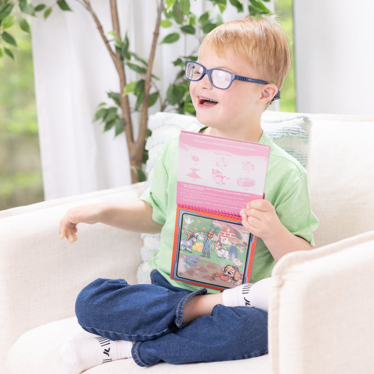 A kid playing with The Melissa & Doug Water WOW! PAW Patrol Skye Reusable Coloring Book with Refillable Water Pen - For Ages 3+