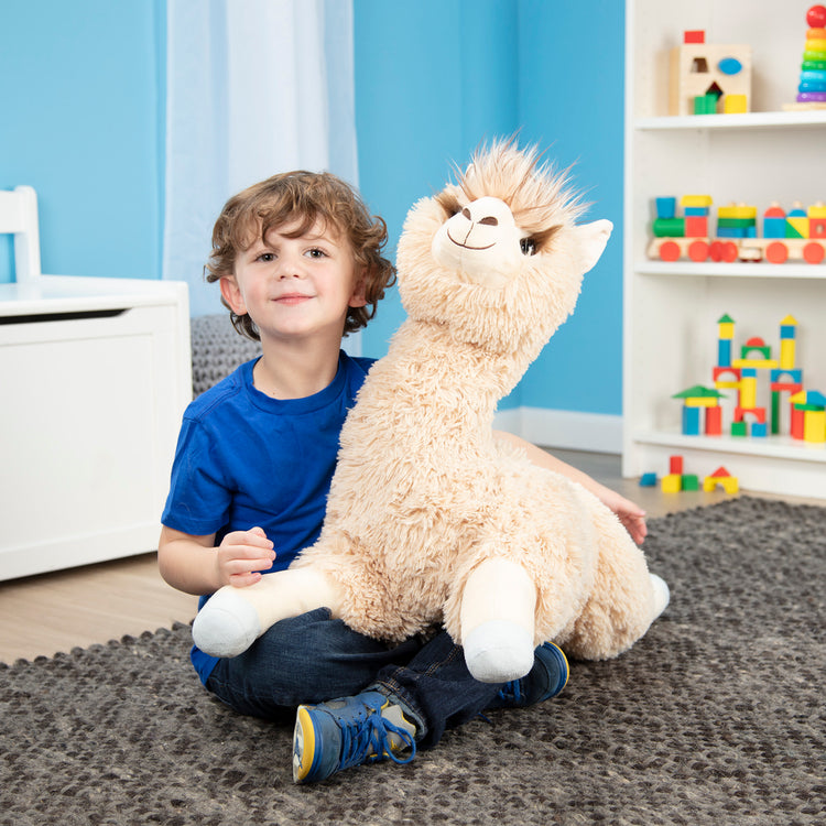A kid playing with The Melissa & Doug Jumbo Llama Stuffed Plush Animal (26 Inches Tall)
