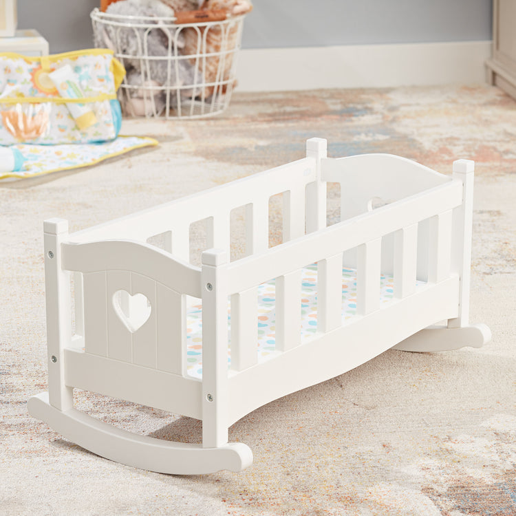 A playroom scene with The Melissa & Doug Mine to Love Wooden Play Cradle for Dolls, Stuffed Animals - White