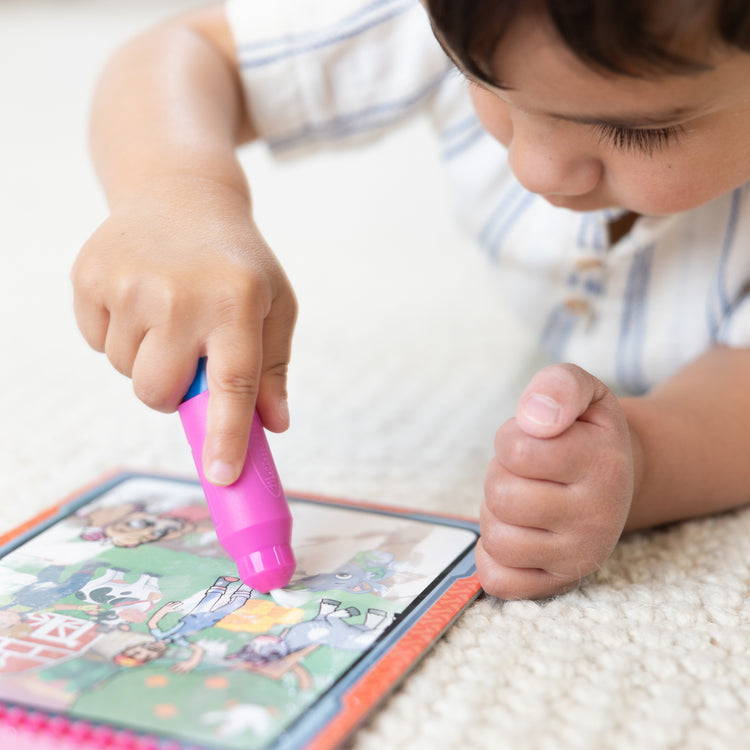 A kid playing with The Melissa & Doug Water WOW! PAW Patrol Skye Reusable Coloring Book with Refillable Water Pen - For Ages 3+