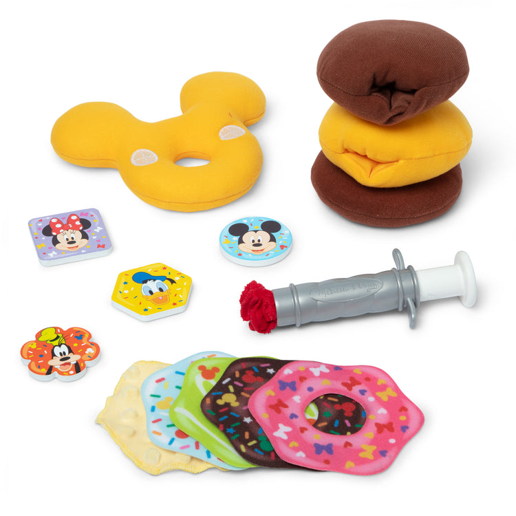 The loose pieces of The Melissa & Doug Disney Fill and Top Donut Play Set with 4 Squishy Donuts and Wooden Toppings - For Ages 3+