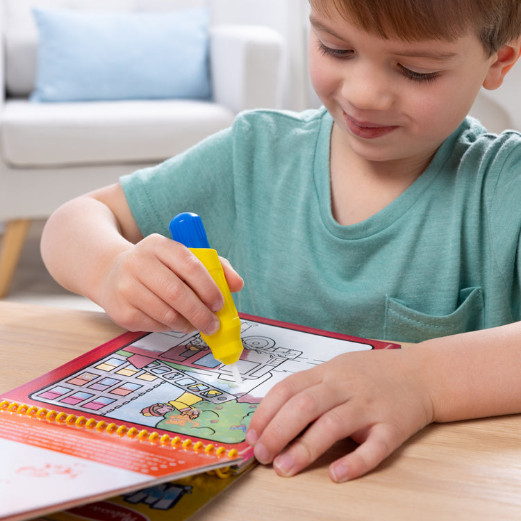 A kid playing with The Melissa & Doug Water WOW! 2-Pack – Animals, Vehicles Water-Reveal Travel Activity Pads 