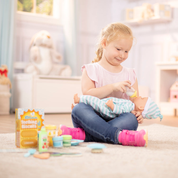 A kid playing with The Melissa & Doug Mine to Love Mealtime Play Set for Dolls with Bottle, Pretend Baby Food Jars, Snack Pouch, More (24 pcs)