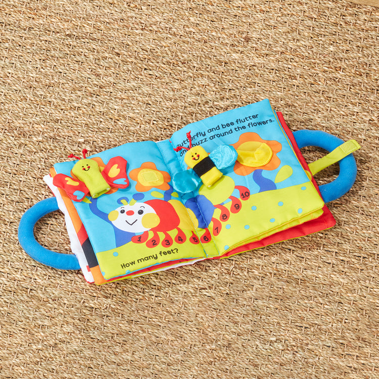 A playroom scene with The Melissa & Doug K’s Kids My First Activity Book 8-Page Soft Book for Babies and Toddlers