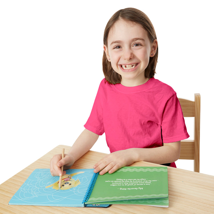 A child on white background with The Melissa & Doug On the Go Scratch Art Hidden-Picture Pad - Favorite Things
