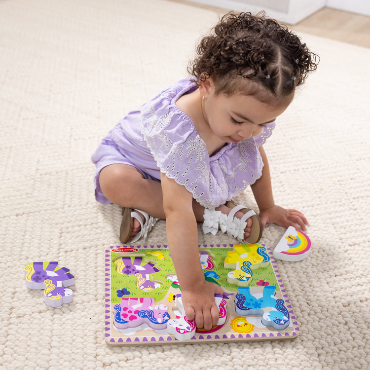 A kid playing with The Melissa & Doug Wooden 6-Piece Unicorn and Rainbow Chunky Puzzle for Toddler Boys and Girls 2+