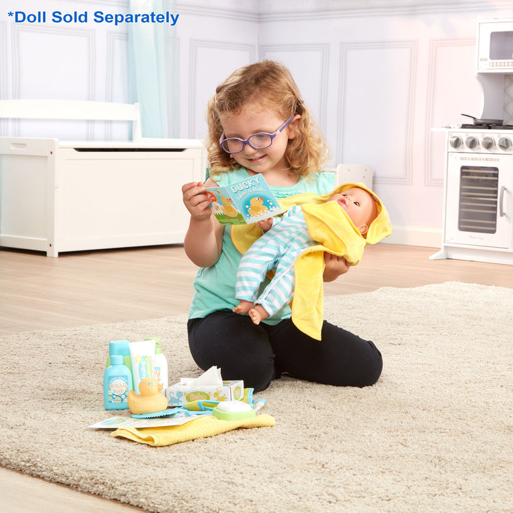 A kid playing with The Melissa & Doug Mine to Love Changing & Bathtime Play Set for Dolls – Diapers, Pretend Shampoo,Wipes, Towel,  More (19 pcs)