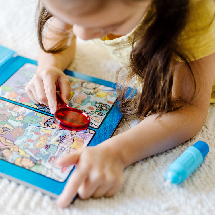 A kid playing with The Melissa & Doug On the Go Water Wow! Reusable Water-Reveal Deluxe Activity Pad – Around Town