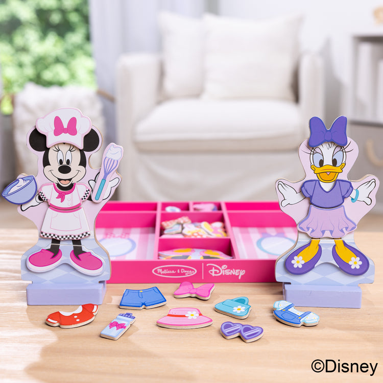 A playroom scene with The Melissa & Doug Disney Minnie Mouse and Daisy Duck Deluxe Wooden Magnetic Dress-Up; 2 Fashion Dolls with Stands for Pretend Play, 52 Pieces