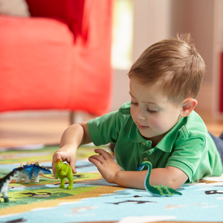 A kid playing with The Melissa & Doug Dinosaur Party Play Set - 9 Collectible Miniature Dinosaurs in a Case