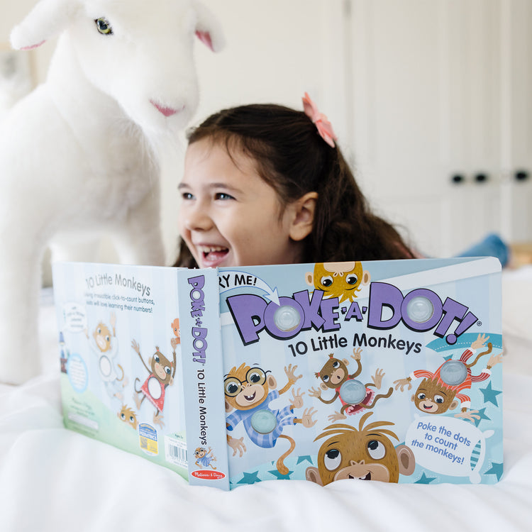 A kid playing with The Melissa & Doug Children's Book - Poke-a-Dot: 10 Little Monkeys (Board Book with Buttons to Pop)