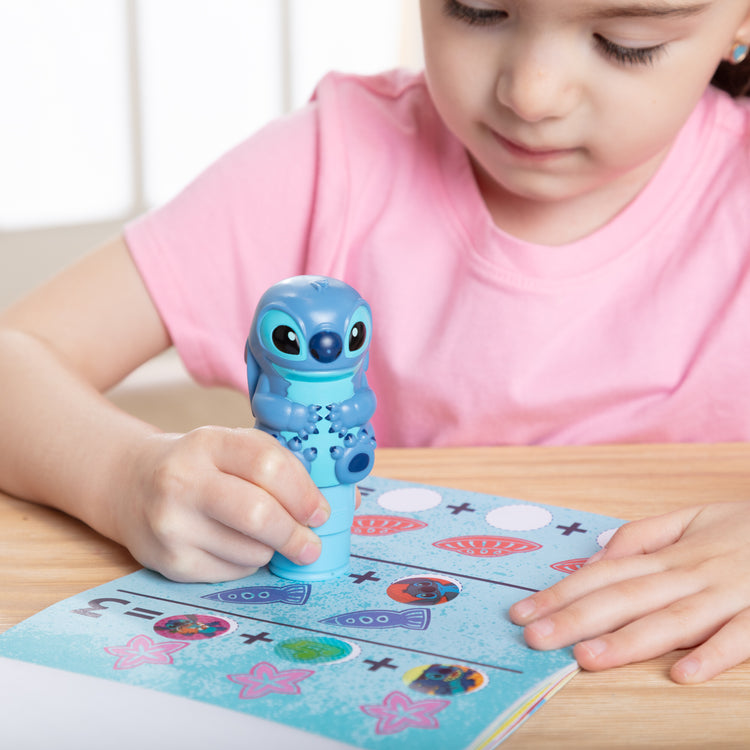 A kid playing with The Melissa & Doug Sticker WOW! Disney Stitch 24-Page Activity Pad with 300 Stickers - For Ages 3+