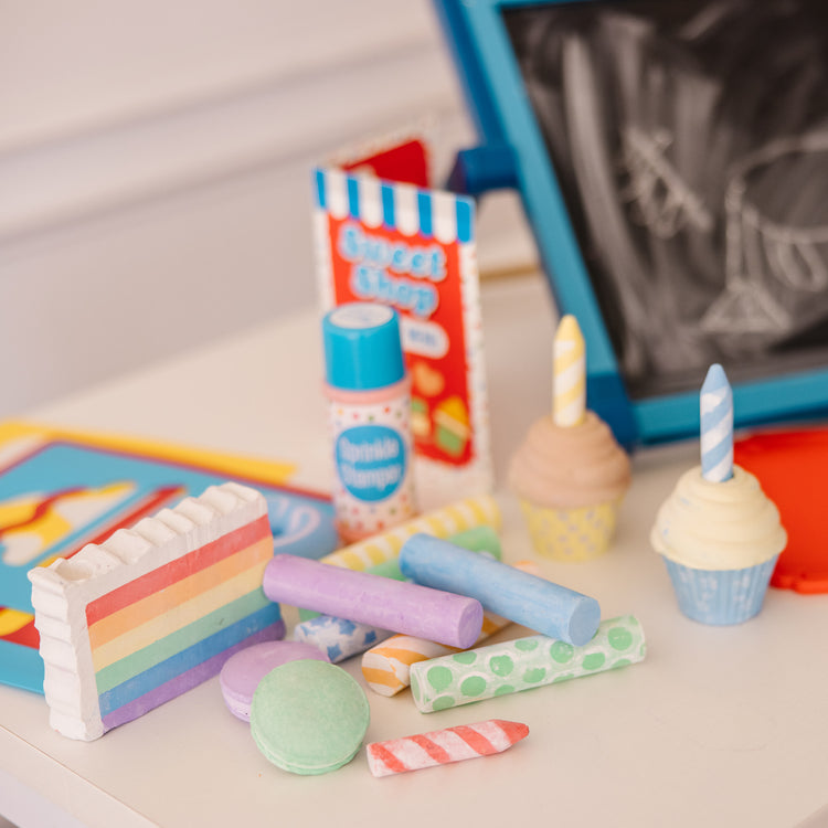 A kid playing with The Melissa & Doug Sweet Shop Multi-Colored Chalk and Holders Play Set - 33 Pieces, Great Gift for Girls and Boys