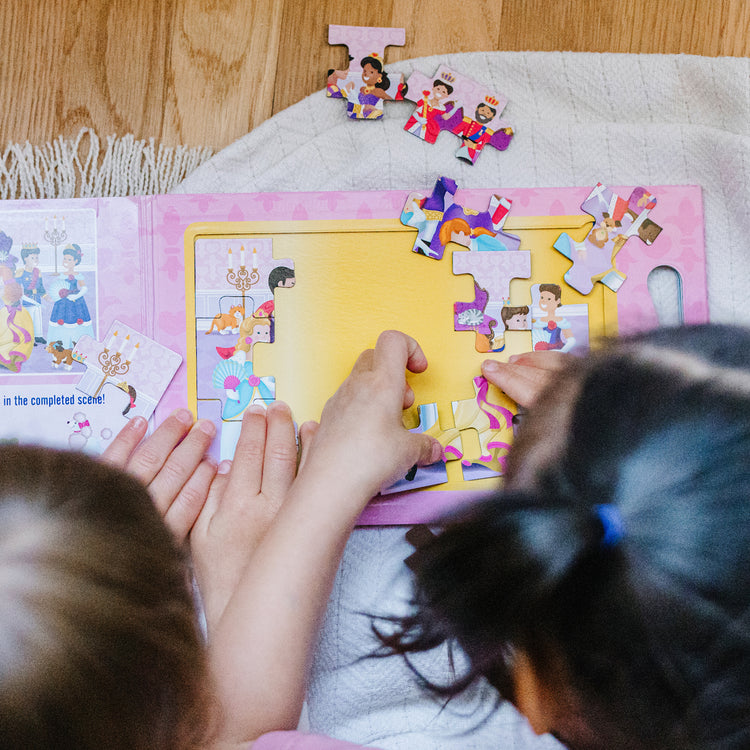 A kid playing with The Melissa & Doug Take-Along Magnetic Jigsaw Puzzles Travel Toy – Princesses (2 15-Piece Puzzles)