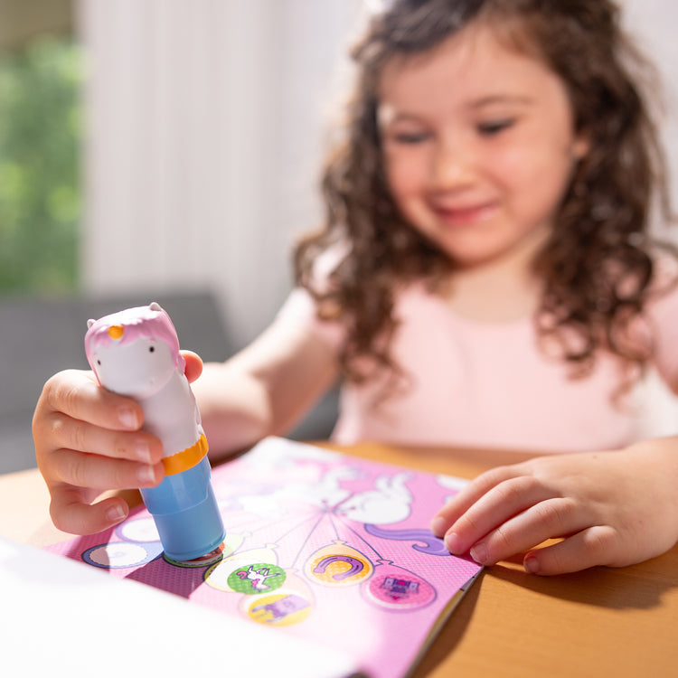 A playroom scene with The Melissa & Doug Sticker WOW!™ 24-Page Activity Pad and Sticker Stamper, 300 Stickers, Arts and Crafts Fidget Toy Collectible Character – Unicorn