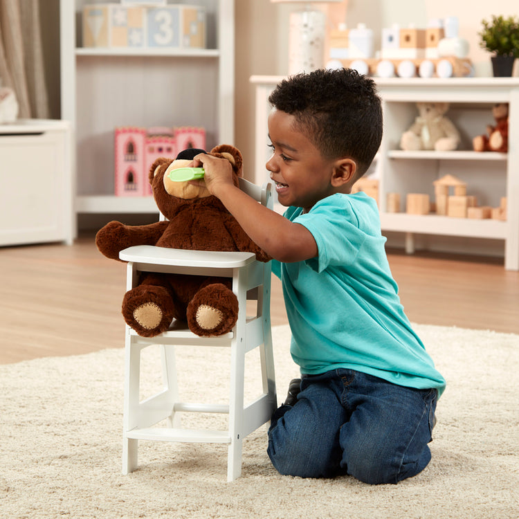 A kid playing with The Melissa & Doug Mine to Love Wooden Play High Chair for Dolls, Stuffed Animals - White (18”H x 8”W x 11”D Assembled)