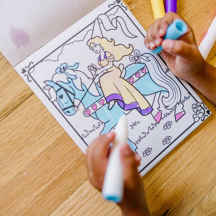 A kid playing with The Melissa & Doug On the Go Magicolor Coloring Pad - Princess (18 Pages)