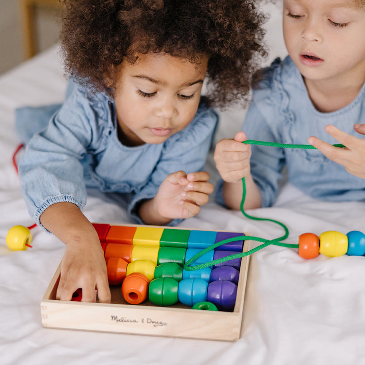 Child playing with lacing beads toy