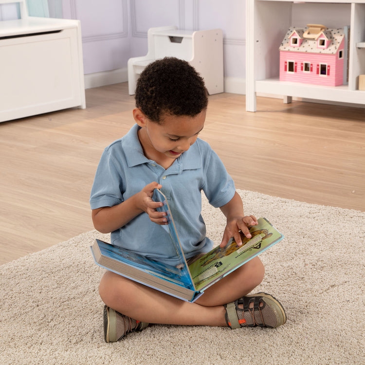 A kid playing with The Melissa & Doug Children's Book - Poke-A-Dot: Dinosaurs A to Z (Board Book with Buttons to Pop)