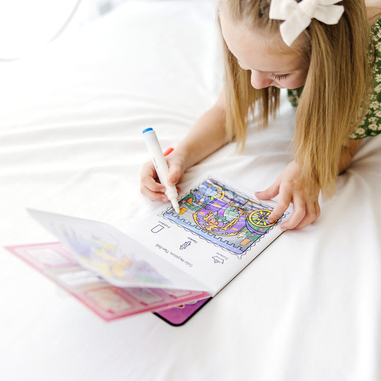 A kid playing with The Melissa & Doug On the Go ColorBlast! Activity Book - Princess (24 Pages)