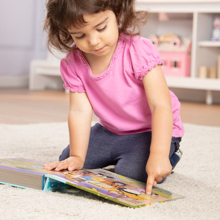 A kid playing with The Melissa & Doug Children's Book - Poke-a-Dot: The Wheels on the Bus Wild Safari (Board Book with Buttons to Pop)