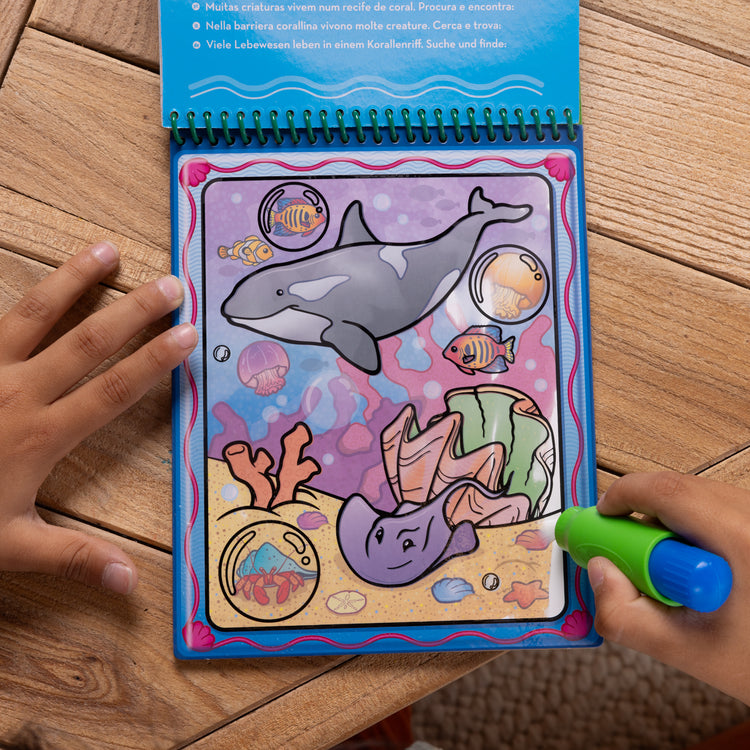 A kid playing with The Melissa & Doug Water WOW! 2-Pack – Animals, Vehicles Water-Reveal Travel Activity Pads 
