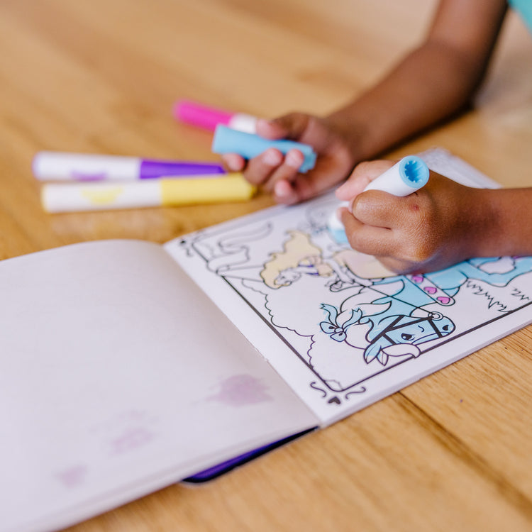 A kid playing with The Melissa & Doug On the Go Magicolor Coloring Pad - Princess (18 Pages)