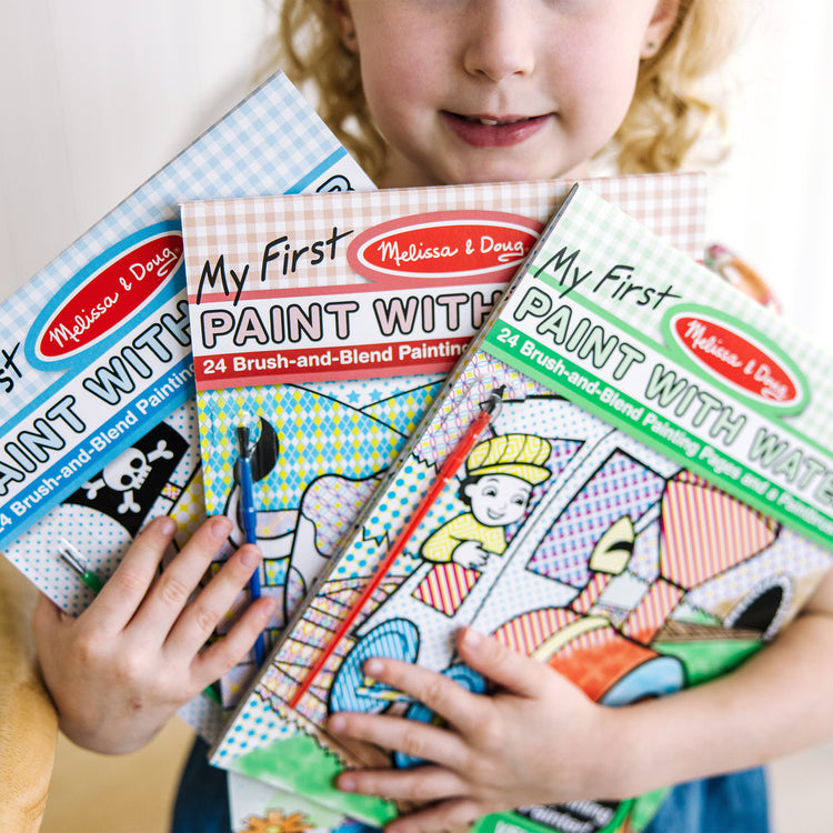 A kid playing with The Melissa & Doug My First Paint With Water Activity Books Set - Animals, Vehicles, and Pirates