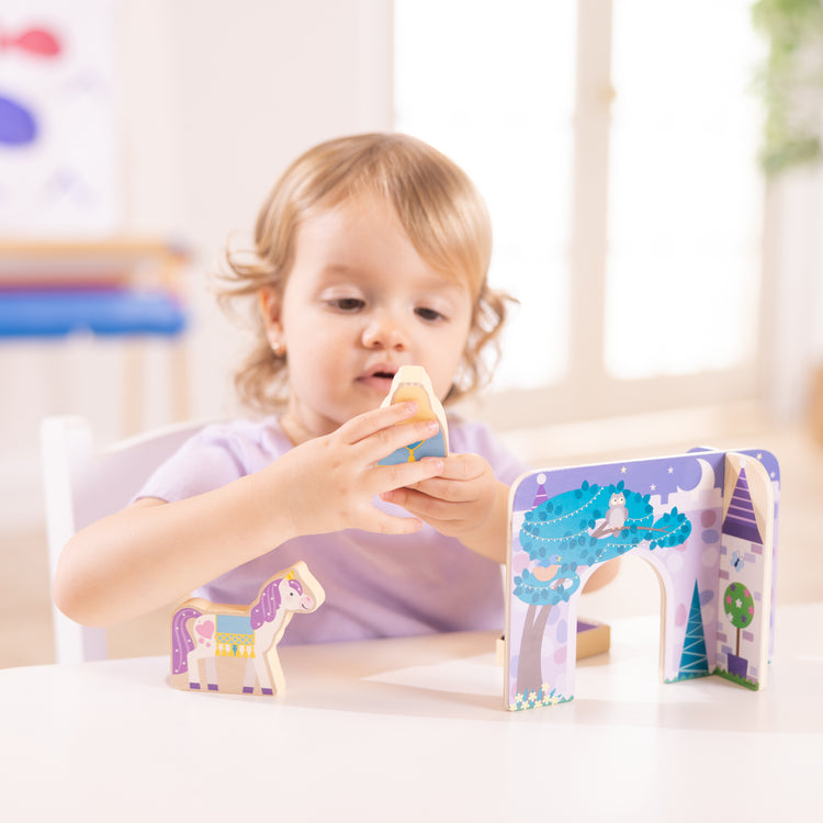 A kid playing with The Wooden Fairy Tale Play Set