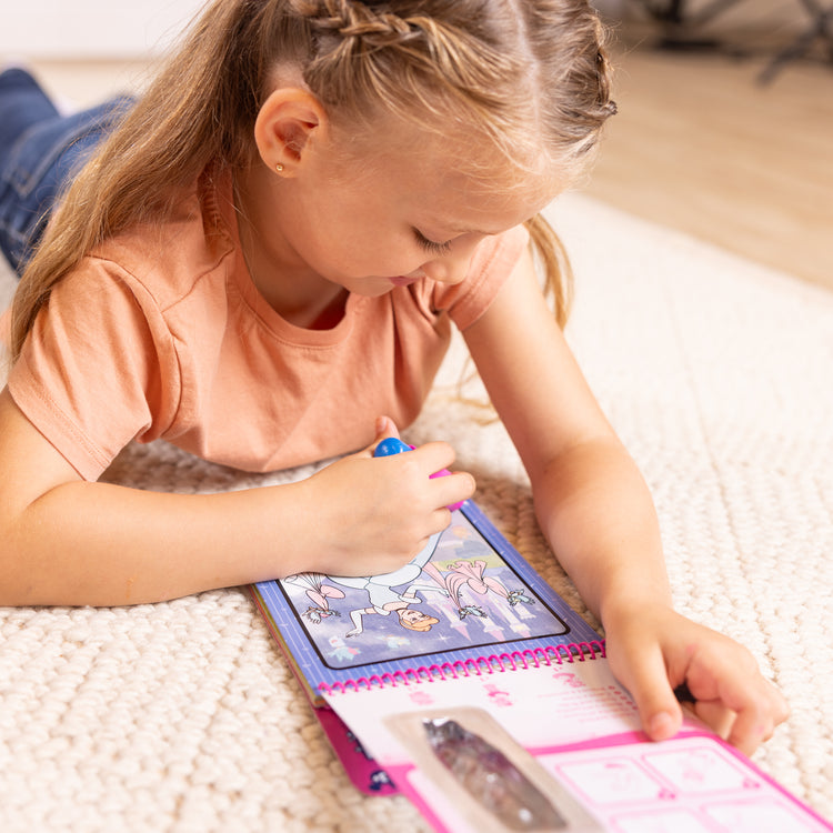 A kid playing with The Melissa & Doug Water WOW! Disney Princess Activity Pad - Mess-Free Reveal Pages - Ages 3+