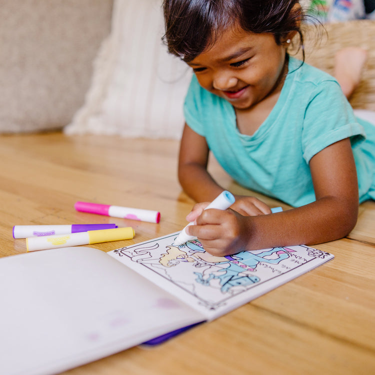 A kid playing with The Melissa & Doug On the Go Magicolor Coloring Pad - Princess (18 Pages)