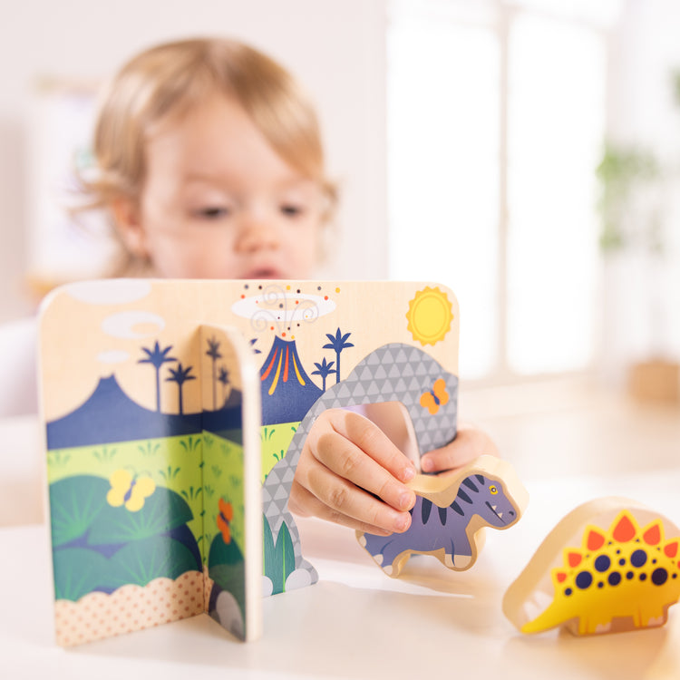 A kid playing with The Wooden Dinosaurs Play Set