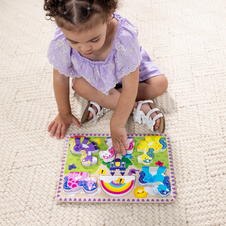 A kid playing with The Melissa & Doug Wooden 6-Piece Unicorn and Rainbow Chunky Puzzle for Toddler Boys and Girls 2+