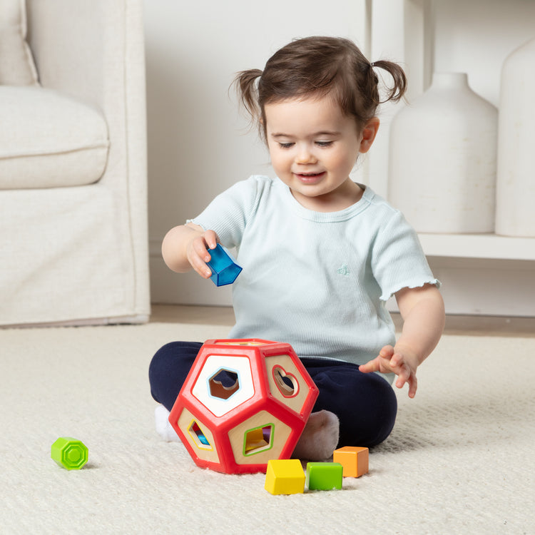 A kid playing with The Shape Sorter Developmental Recolor
