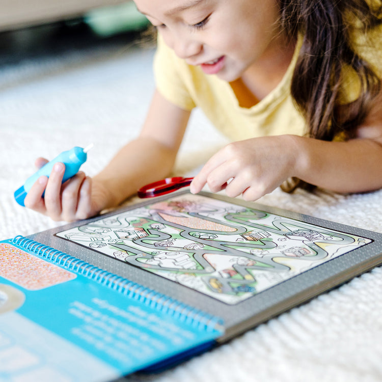 A kid playing with The Melissa & Doug On the Go Water Wow! Reusable Water-Reveal Deluxe Activity Pad – Around Town