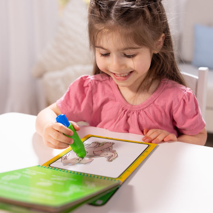 A kid playing with The Melissa & Doug On the Go Water Wow! Reusable Water-Reveal Coloring Activity Pad Travel Toy for Boys and Girls– Jungle