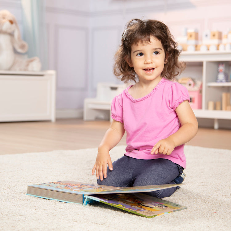 A kid playing with The Melissa & Doug Children's Book - Poke-a-Dot: The Wheels on the Bus Wild Safari (Board Book with Buttons to Pop)