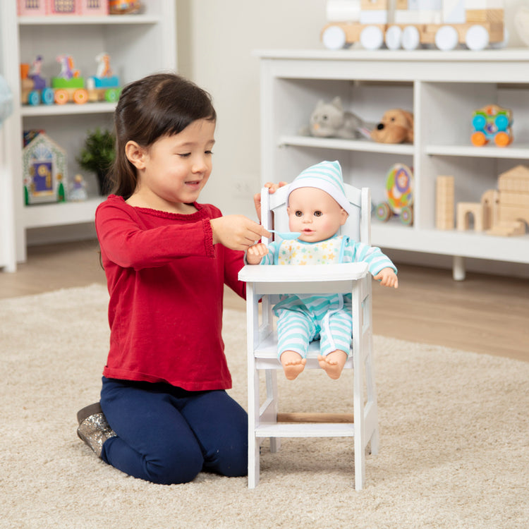 A kid playing with The Melissa & Doug Mine to Love Wooden Play High Chair for Dolls, Stuffed Animals - White (18”H x 8”W x 11”D Assembled)